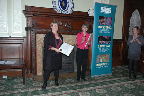 Artist Rachel Mello receives a citation of excellence from Rep. Denise Provost