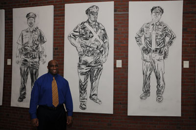 Northeastern Police Officer Mike Blue standing in front of his portrait.