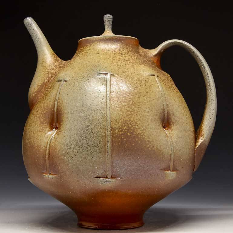 A photograph of a bulbous brown and tan teapot with button-like indentations.