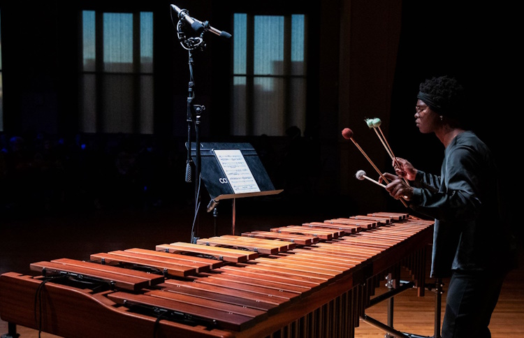 Photograph of a marimba player concentrating intently on a musical performance.