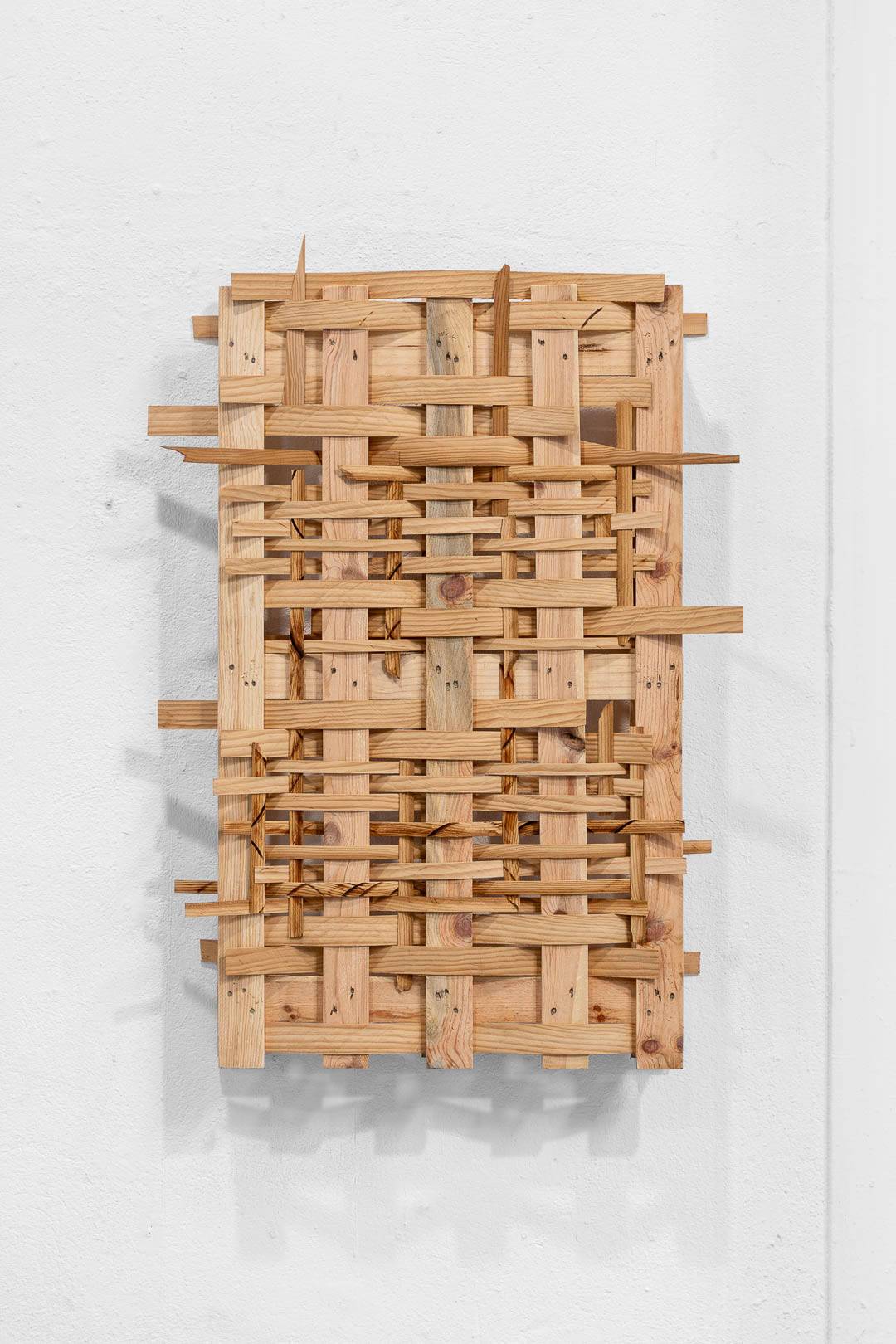 Abstract rectangular sculptural of interwoven wood strips.