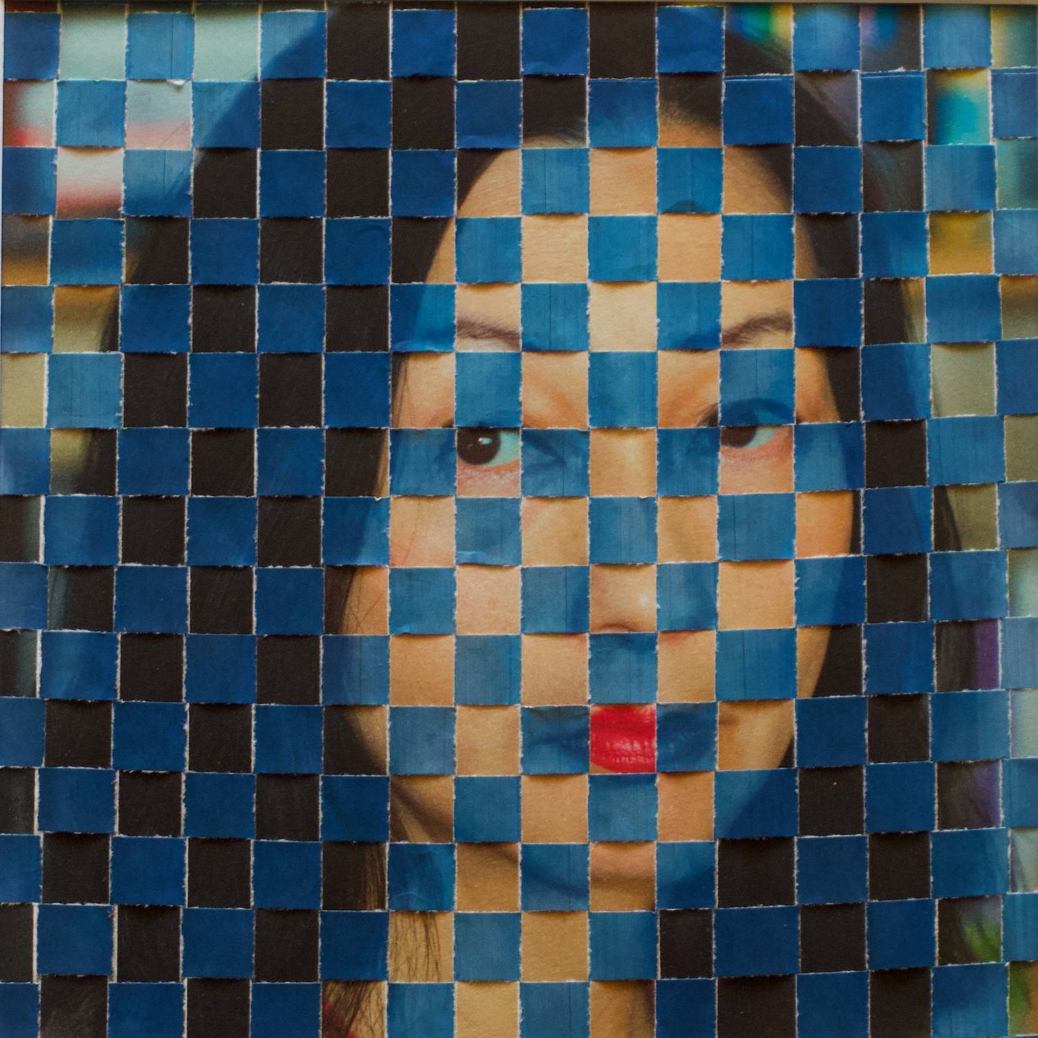 Collaged photo in which a grid of blue squares is superimposed on an image of an Asian woman's face.