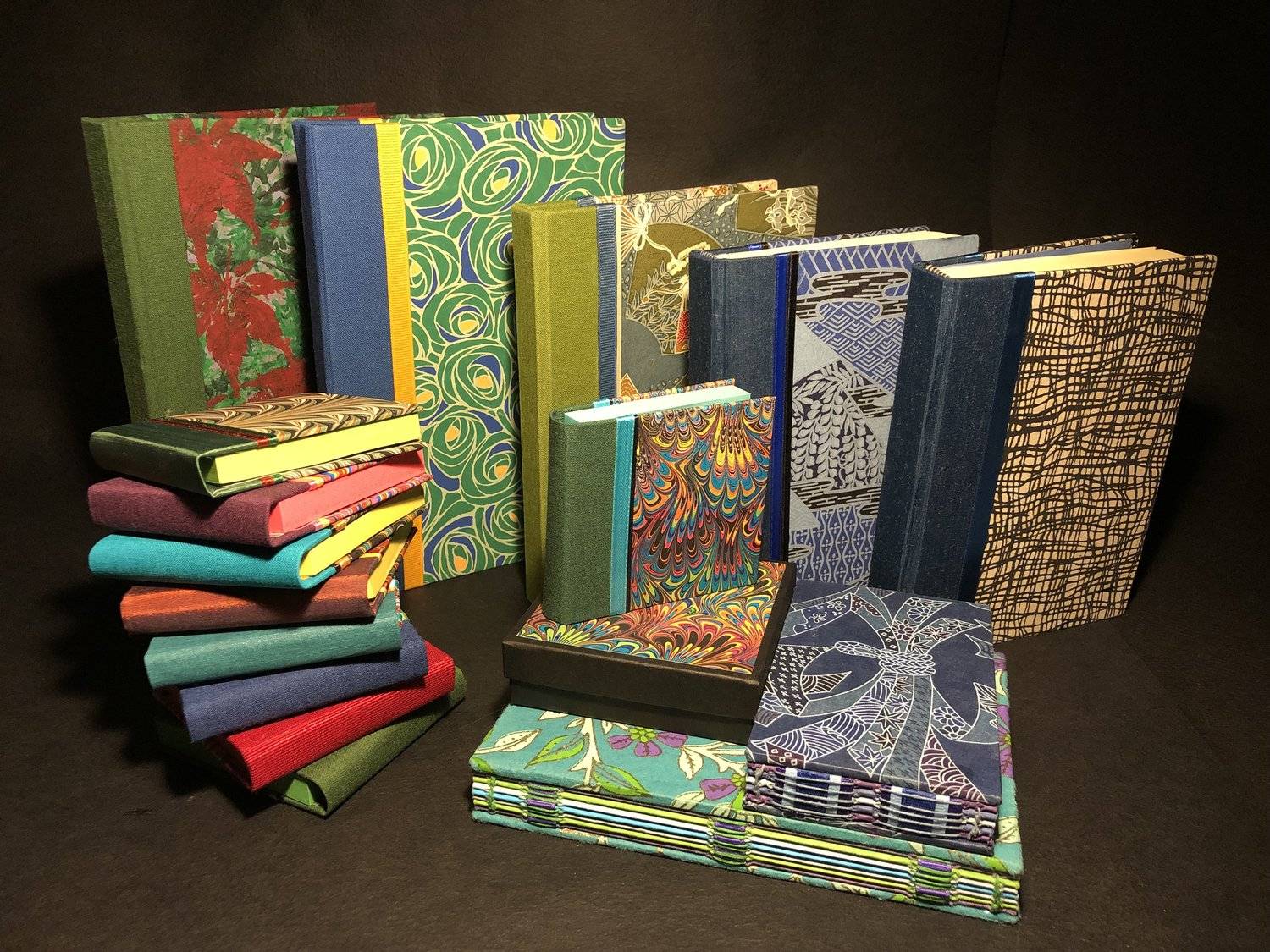 Photograph of a variety of books with hand-made covers and binding.